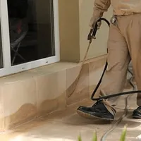 General pest control technician spraying exterior perimeter around a home in Mesa, AZ